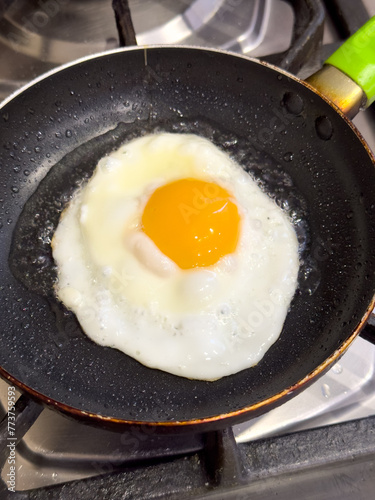 The egg is fried in a frying pan. Close-up