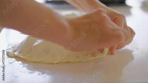 Chef pinches a calzone before baking in the oven, live video of a traditional Italian dessert, gastronomic trip to Italy, blurred background and selective focus