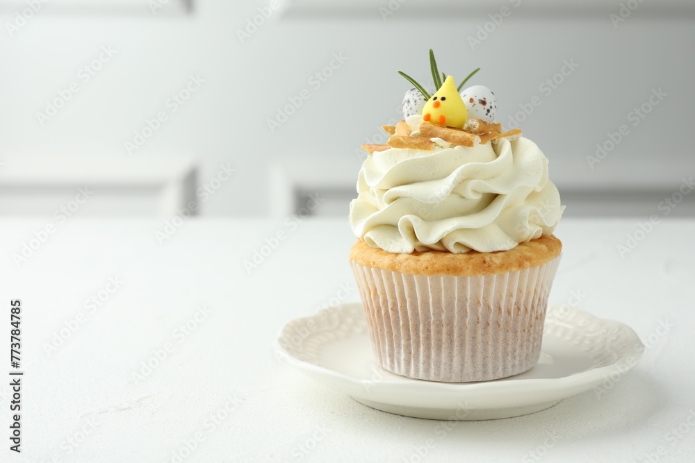 Tasty Easter cupcake with vanilla cream on white table, space for text - obrazy, fototapety, plakaty 