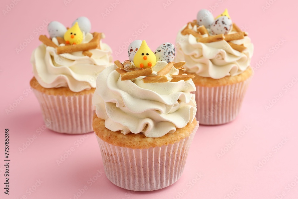 Tasty Easter cupcakes with vanilla cream on pink background, closeup Tasty Easter cupcakes with vanilla cream on pink background, closeup