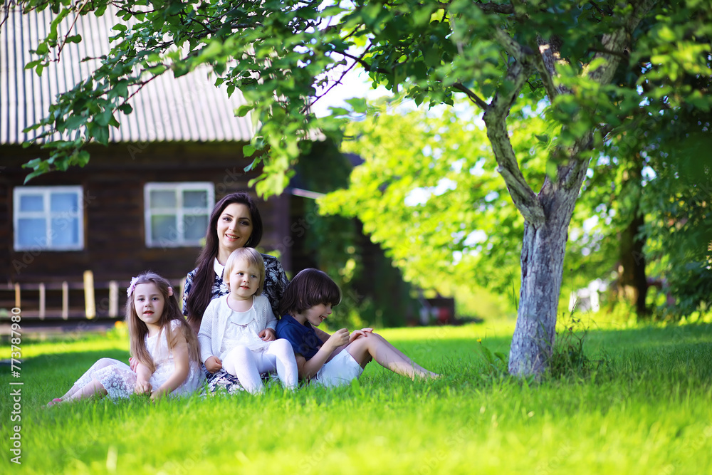 Young large family on a summer morning walk. Beautiful mother with children is playing in the park. Young large family on a summer morning walk. Beautiful mother with children is playing in the park.