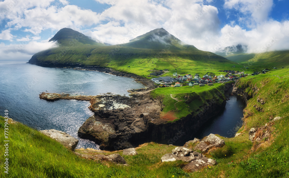 Village of Gjogv on Faroe Islands with colourful houses. Mountain landscape with ocean coast