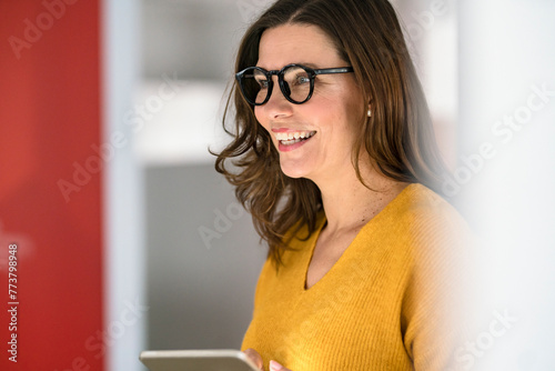 happy mature businesswoman in eyeglasses at creative office photo