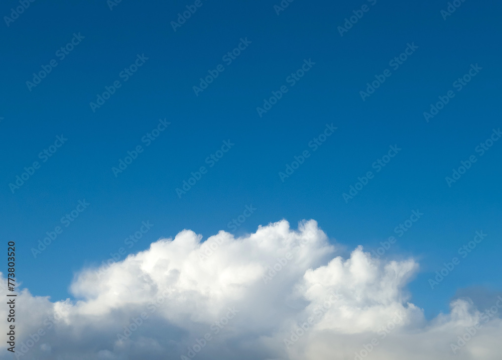 White fluffy cumulus clouds in the summer sky, natural clouds background