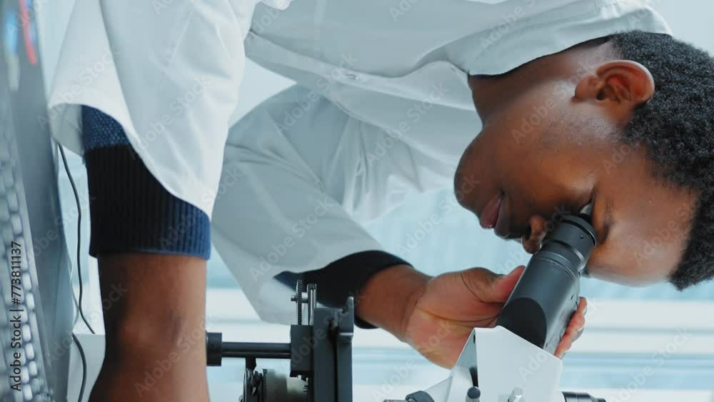 African-American Man Looking In Microscope African-American Man Looking In Microscope