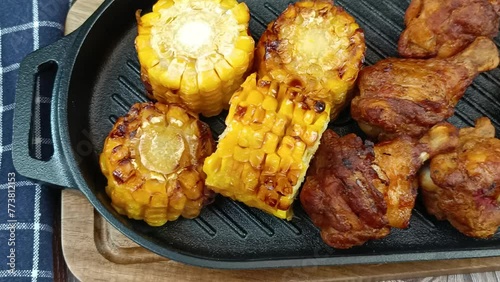 pilons de poulet et maïs grillé sur un grill en fonte photo