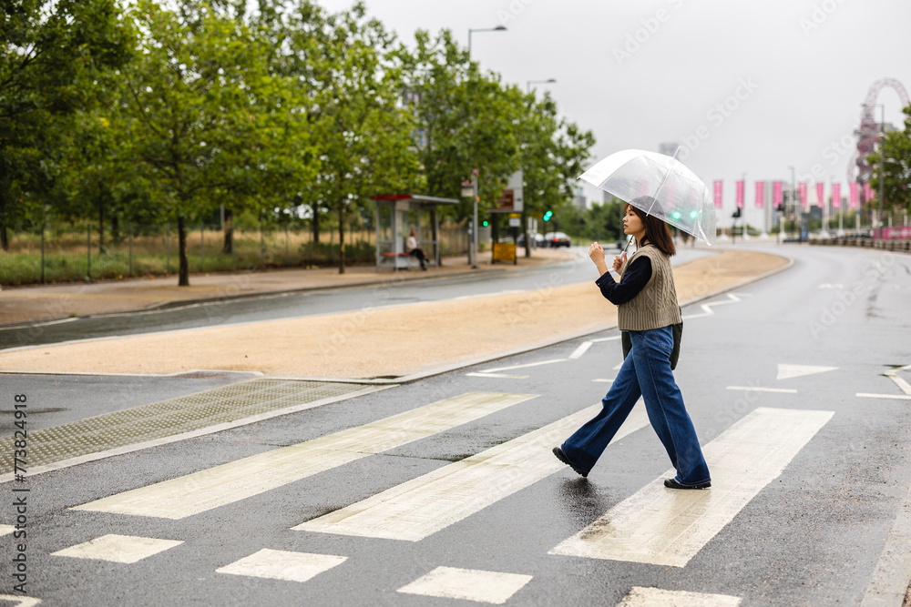 Asian woman crossing pedestrian crossing