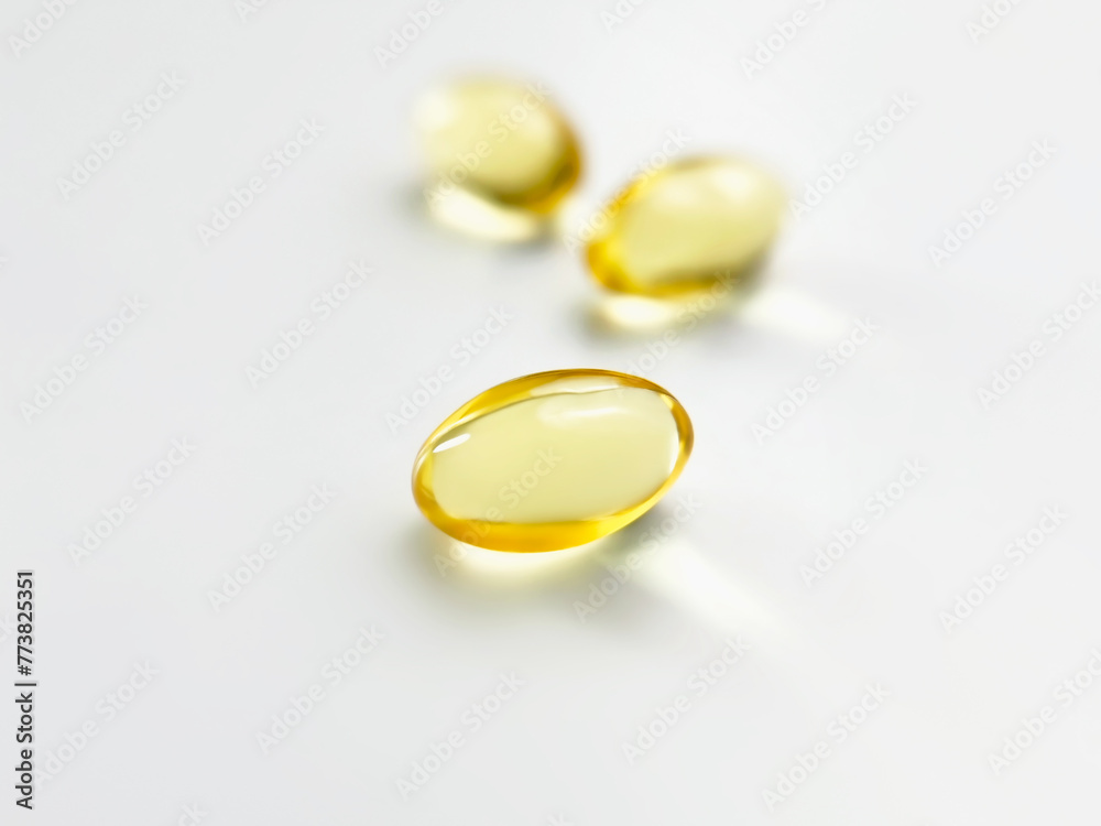 yellow vitamin capsules on a white background close-up yellow vitamin capsules on a white background close-up