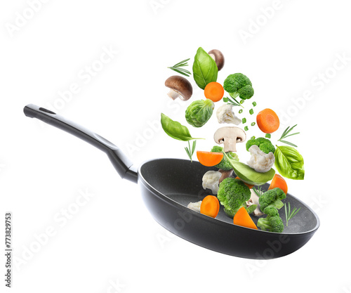 Frying pan with fresh ingredients in air on white background