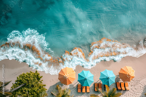 Aerial shot of a tropical ocean beach with palm trees, deck chairs and umbrellas	