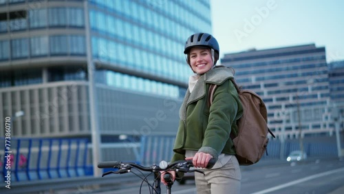 Young urban woman traveling around the city by bike, cycling to work, university to save money. Concept of bike commuting in the city, sustainable lifestyle. photo