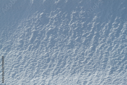 Snow texture. Background of pure blue and white snow. Winter pattern.