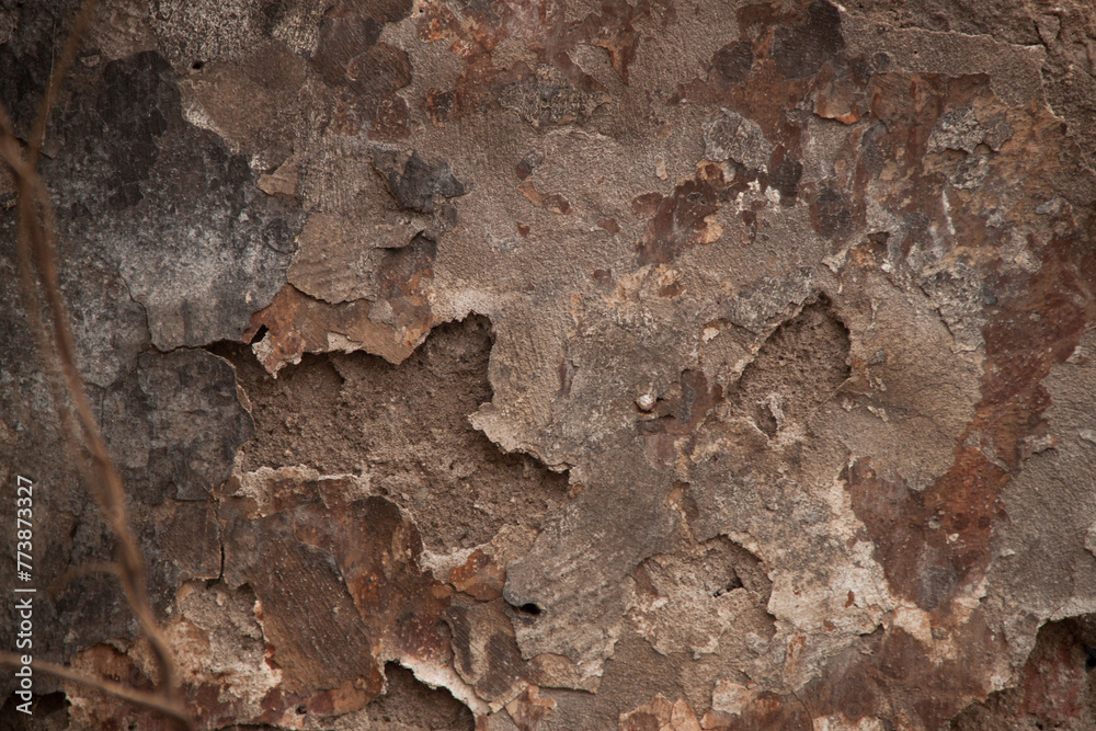 Texture of an old ragged wall background of old bricks and cracks in plaster yellow and brown tones Texture of an old ragged wall background of old bricks and cracks in plaster yellow and brown tones