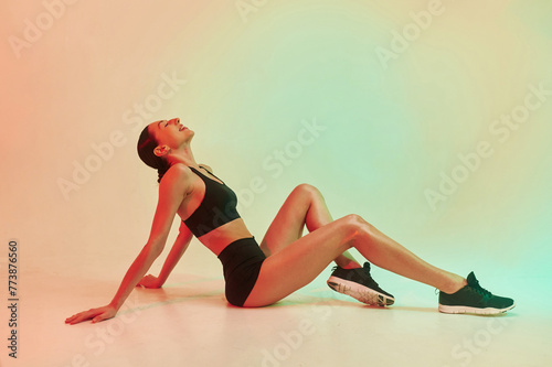 Professional yoga practitioner. Young fitness woman in sportive clothes against background in studio