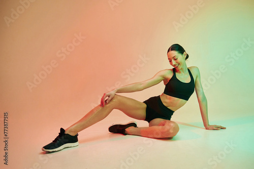 Skinny body shape. Young fitness woman in sportive clothes against background in studio