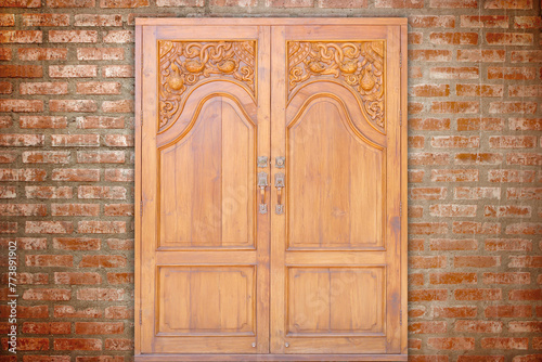 carving teak entrance wooden door on vintage wall