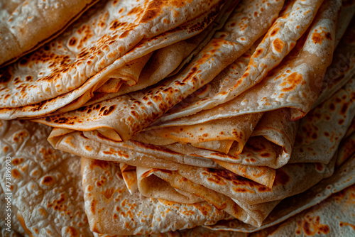 Close-up image of a stack of golden brown crepes, highlighting the textures and details