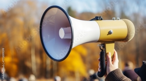 Hand holding bullhorn with space for text. Megaphone concept for announcements and protests © chelmicky