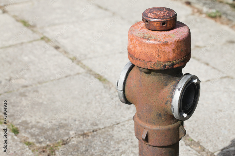 Red paint fire hydrant. Isolated on pavement. Fire department water supply for emergency. Old rusty peeling paint grunge metal valve that needs replacement. Outdoor park emergency water supply. Red paint fire hydrant. Isolated on pavement. Fire department water supply for emergency. Old rusty peeling paint grunge metal valve that needs replacement. Outdoor park emergency water supply.