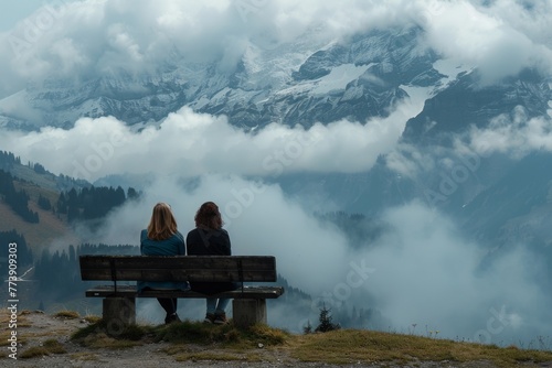 Two women sitting on a wooden bench while enjoying the nature landscape