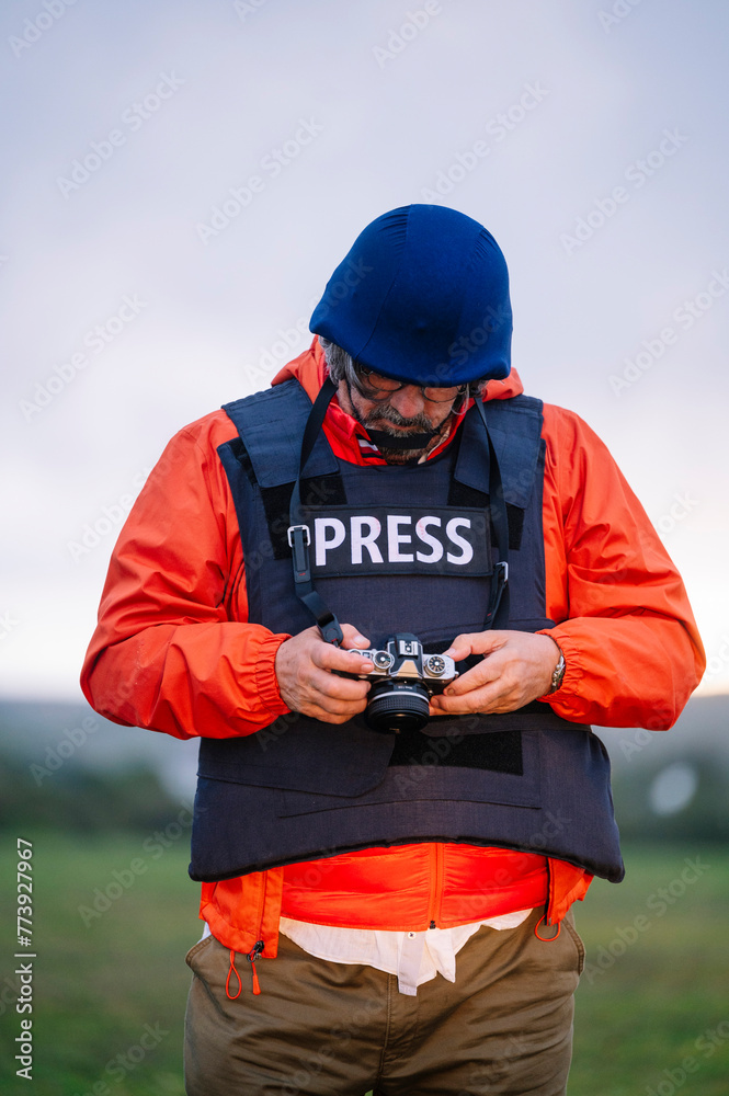 Reporter in bulletproof vest holding a camera. Reporter in bulletproof vest holding a camera.