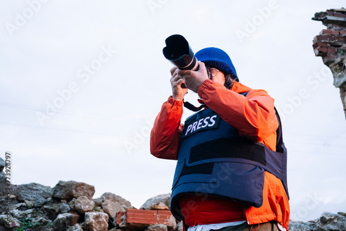Cuadro en lienzo Reporter in bulletproof vest holding a camera.