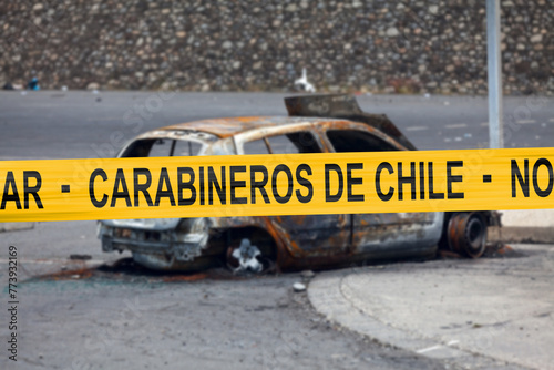 Chilean carabineer tape in front of a burnt car