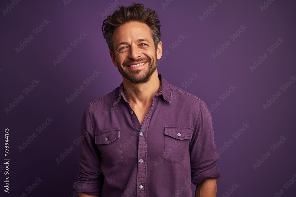 Obraz premium A man is smiling and wearing a purple shirt