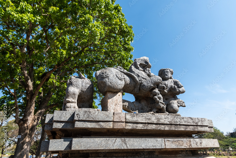 Obraz premium A ruined stone sculpture of a figure fighting a lion at the entrance to the ancient Hoysaleshwara temple complex in Halebidu in Karnataka.