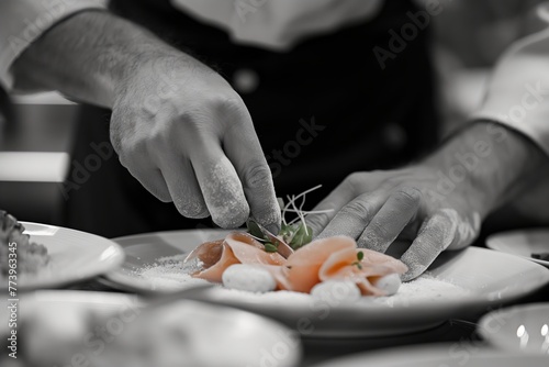 A chef garnishes a plate of smoked salmon, black and white with a color pop effect.