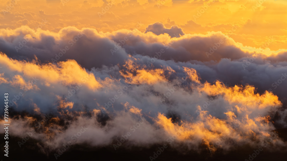 Naklejka premium Tranquil view of the amazing sunrise through the clouds over Haleakala volcano summit at Haleakala National Park on the island of Maui, Hawaii, USA 