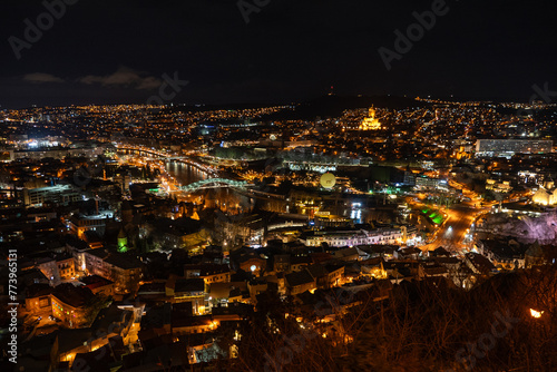 View across the city of Tbilisi, Georgia at night.. Aerial drone night photo of Tbilisi. Mother of Georgia in Sololaki hill Georgia.Night view of old town in Tbilisi