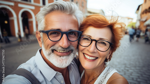 Couple of gray haired mature smiling people travel and taking selfie portrait on phone. Wonderful cheerful man and woman. Active retirees are enjoying life. A man with a gray beard and a woman, travel