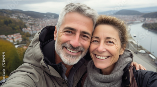 Couple of gray haired mature smiling people travel and taking selfie portrait on phone. Wonderful cheerful man and woman. Active retirees are enjoying life. A man with a gray beard and a woman, travel