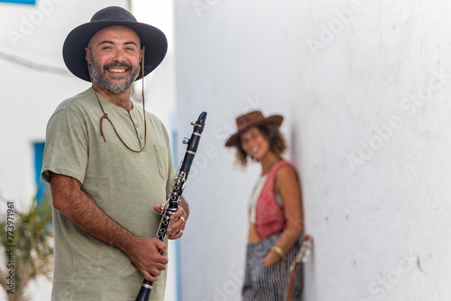 Smiling street music duo against a white wall photo
