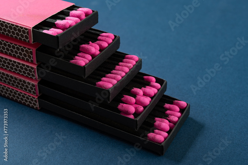 pink matchboxes stacks up on a blue background © Freer