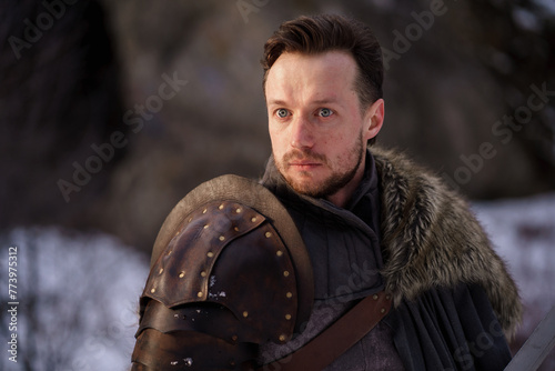 Prtrait medieval knight with sword in armor as style Game of Thrones in winter forest