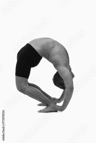 Tirieng Mukha Uttanasana (inhale), Ashtanga yoga  Side view of man wearing sportswear doing Yoga exercise against white background. Black and wwhite image. photo