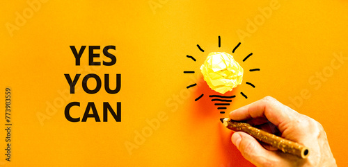Motivational Yes you can symbol. Concept words Yes you can on beautiful orange paper. Beautiful orange background. Light bulb. Businessman hand. Business motivational Yes you can concept. Copy space