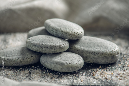 Natural soap in the shape of stones on a black background covered with sea salt. Concept of organic cosmetics and spa treatments