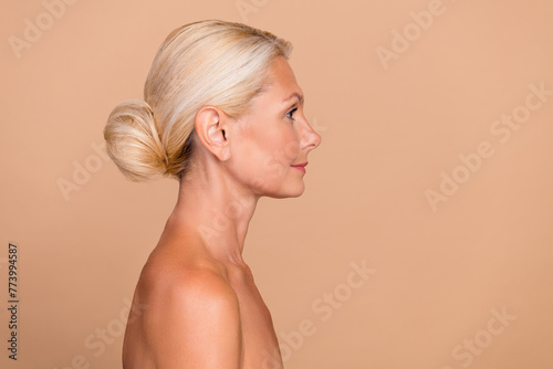 Photo of smiling pretty nude lady wear nothing looking empty space isolated beige color background