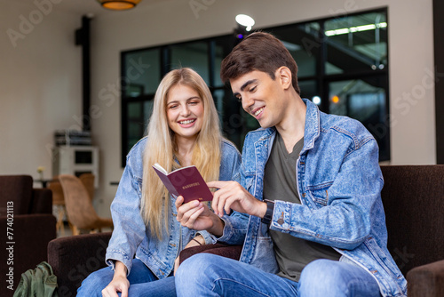 Caucasian traveller couple is looking at visa permit in the passport while waiting in airline business departure lounge terminal waiting for boarding airplane
