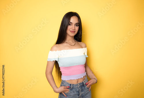 Young brunette woman over isolated yellow background laughing