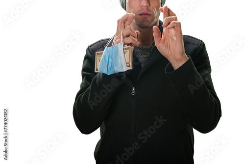 Young man with pack of money in medical mask gesturing and trying to protect himself from Loosing money during pandemic, Dollar currency display: Detailed close-up of man's hands with cash,