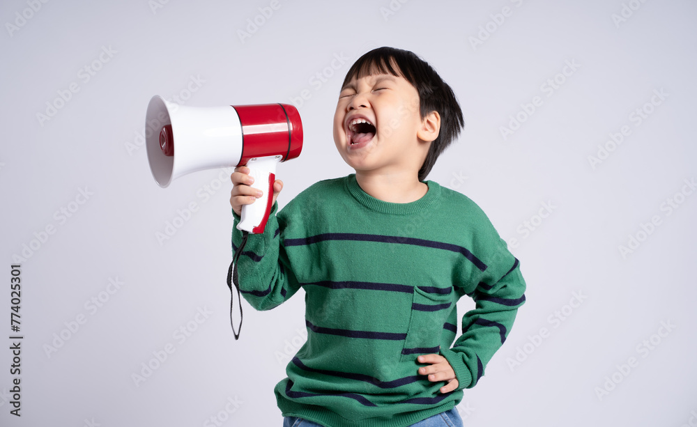 © STOCK88PHOTOGRAPHER - Portrait of an Asian boy holding hand speaker on the white background © STOCK88PHOTOGRAPHER - Portrait of an Asian boy holding hand speaker on the white background
