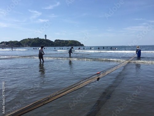 江の島と地引網とサーファー
