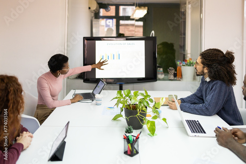 Diverse team analyzing sales data during meeting photo