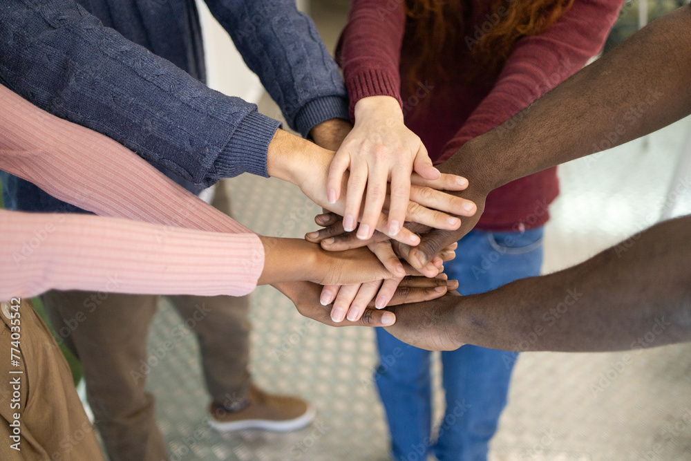Diverse team showing unity with a hands stack Diverse team showing unity with a hands stack