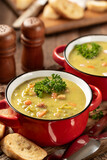 Bowls of split pea soup with ham and carrots garnished with parsley