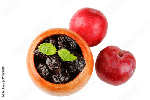 Dried plum in wooden bowl isolated on a white background top view